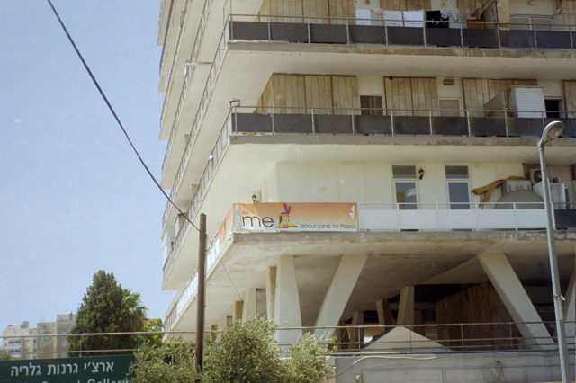 Sign near SuperSol - "Ask me about Land for Peace" [With image of Indian]