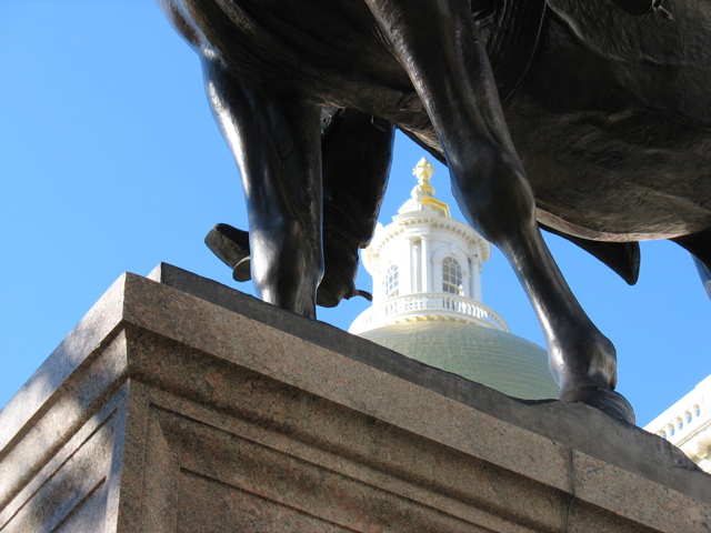 The top of the State House through the legs of the horse of General Joseph Hooker