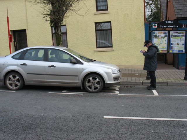 Cop gives a ticket to a car obviously parked in a bus space