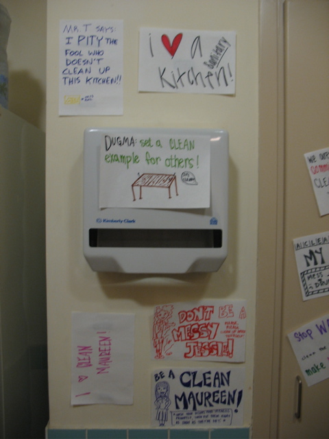 6 signs next to the closet: "Mr. T says: I PITY the fool who doesn't clean up this kitchen!!" "I love a sanitary kitchen" "Dugma: set a CLEAN example for others!" "I love Clean Maureen!" "Don't be a Messy Jessie. Please please clean up after yourself" "Be a Clean Maureen! Wash your dishes and utensils promptly, then put them away as soon as they're dry!"