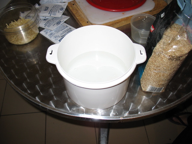 The empty cooker with the rice next to it.