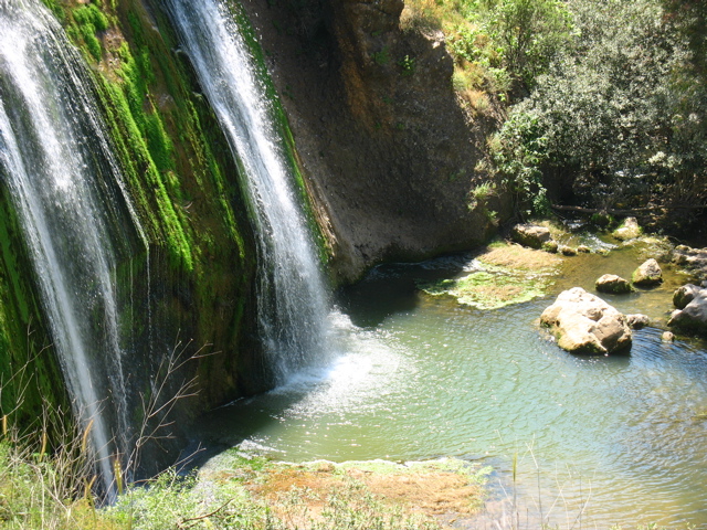 The waterfall cascades into the pool